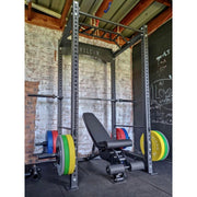 Commercial power cage with colour bumper plates in home gym