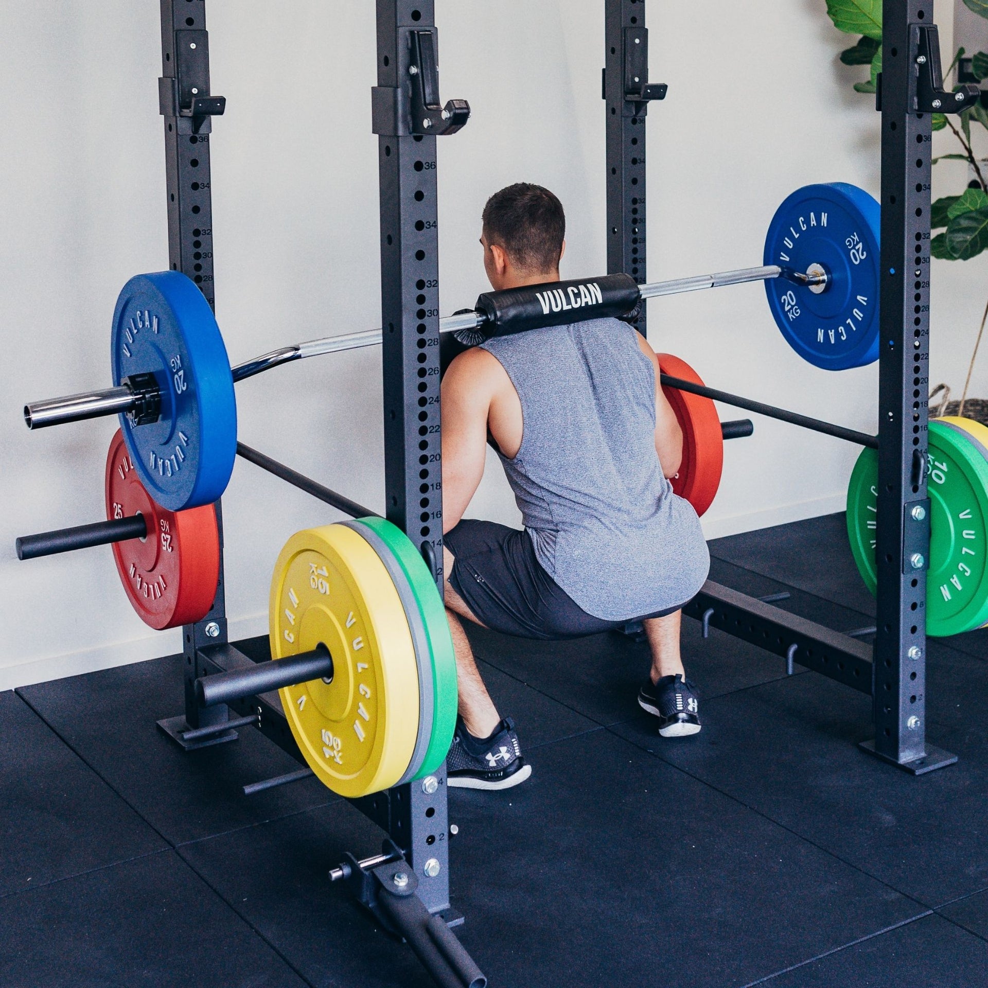 A person lifting weights using the Olympic Safety Squat Bar within a Power Rack