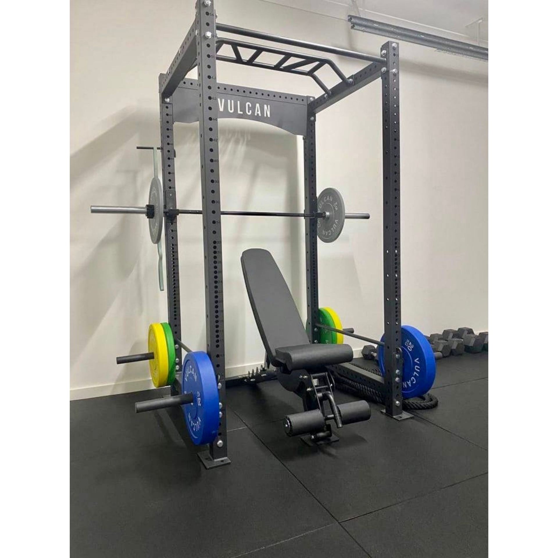Commercial power cage with colour bumper plates, adjustable bench in home gym